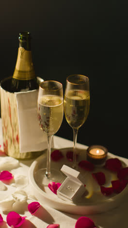 Vertical-Video-Of-Table-Set-For-Romantic-Marriage-Proposal-With-Champagne-And-Engagement-Ring-At-Night-2